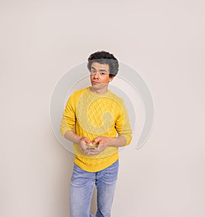 Portrait of confident young businessman using social media on smart phone against white background