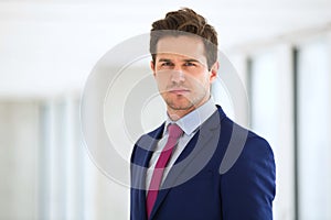 Portrait of confident young businessman wearing suit in office