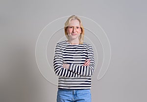 Portrait of confident young businesswoman with arms crossed standing over isolated white background
