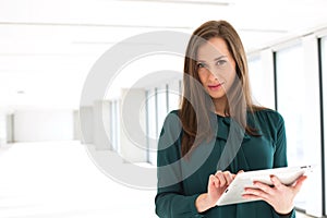 Portrait of confident young businesswoman using digital tablet in office