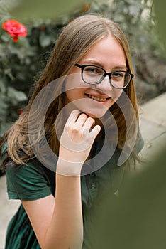Portrait of confident young girl with eyeglasses, smiling. Blonde hair, natural, beautiful teen age girl. Summer portrait