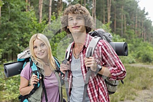 Portrait of confident young hiking couple in forest