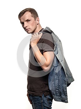 Portrait of a confident young man with jeans jacket on a white b