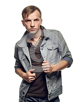 Portrait of a confident young man in jeans jacket on a white