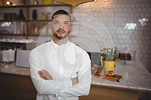 Portrait of confident young man standing with arms crossed