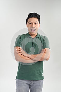 Portrait of confident young man standing arms crossed on gray background