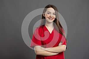 Portrait of a confident young nurse with braces wearing red scrubs photo