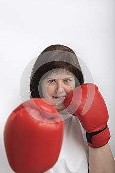 Portrait of confident young woman in boxing gloves on white background. Feminism. Woman fights for justice