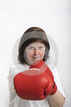 Portrait of confident young woman in boxing gloves on white background. Woman fights for justice. Feminism