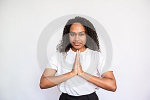 Portrait of confident young woman looking at camera and praying