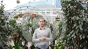 Portrait of confident young woman successful owner of greenhouse