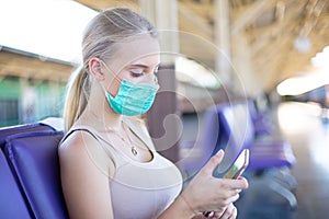 Portrait of confident young woman traveling by train, and wear protective face mask to prevent the spread of coronavirus, Covid-19