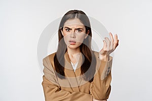 Portrait of confused businesswoman, staring puzzled and frustrated, cant understand smth, standing in suit over white