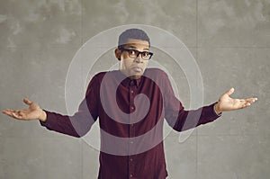 Portrait of confused handsome young african american man with raised arms