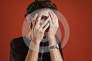 Portrait of a confused man covering his face
