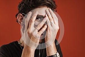 Portrait of a confused man covering his face