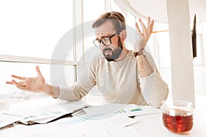 Portrait of a confused man working with documents