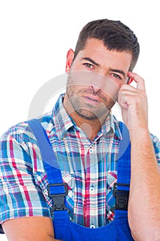Portrait of confused manual worker scratching head
