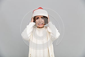 Portrait of a confused puzzled girl in christmas hat