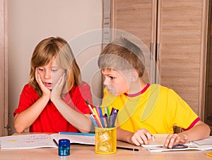 Portrait confused, unhappy, stressed tired, frightened girl doing homework with brother. School and education concept. Facial exp