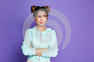 Portrait of confused woman with two buns twisting mouth and look