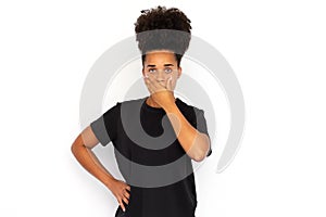 Portrait of confused young woman covering mouth with hand