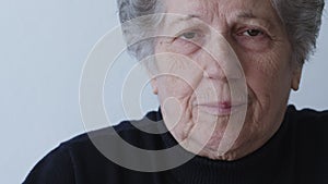 Portrait of a contemplative elderly woman in a warm sweater indoors