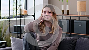 Portrait Of A Content Woman Relaxing On Sofa At Home