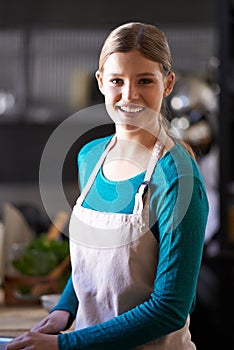 Portrait, cooking and woman with ingredients in kitchen cutting food with knife at home. Happy, groceries and female