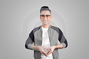 Portrait of cool handsome asian man with hands making heart shape