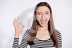 Portrait of cool student making ok sign winking wearing striped pullover  over white background