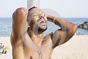 Portrait of cool young African man dancing at the beach on summer day.