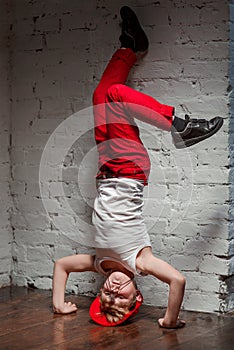 Portrait of cool young hip hop boy standing on his head