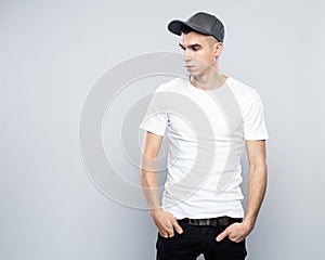 Portrait of cool young man in baseball cap and white t-shirt