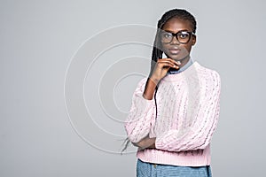 Portrait of thoughtful woman holding hand on chin looking up trying to find solution isolated on grey background