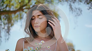 Portrait countryside model hold flowers in rural nature. Woman camomiles bouquet