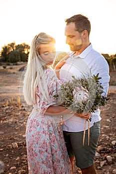 Portrait of a couple with a bouquet during a warm sunset