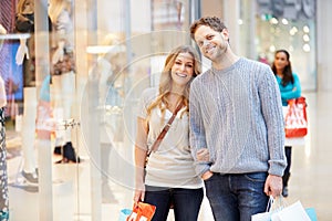 Portrait Of Couple Carrying Bags In Shopping Mall