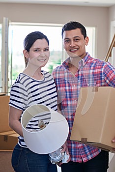 Portrait Of Couple Carrying Boxes Into New Home On Moving Day
