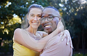 Portrait, couple on a date and hug with love in nature, outdoor in park with commitment in interracial relationship