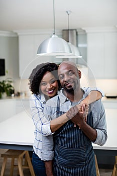 Portrait of couple embracing each other in kitchen