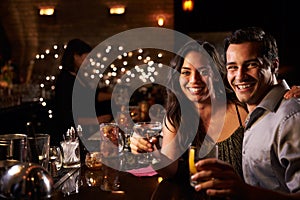 Portrait Of Couple Enjoying Night Out At Cocktail Bar