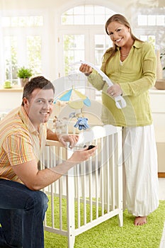 Portrait of couple fixing baby bed photo