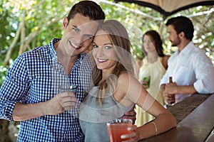 Portrait of couple having a glass of cocktail at counter