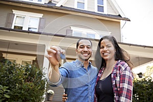 Portrait Of Couple Holding Keys To New Home On Moving In Day