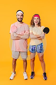 Portrait of couple holding rackets while playing table tennis together