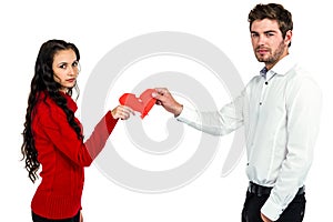 Portrait of couple holding red cracked heart shape