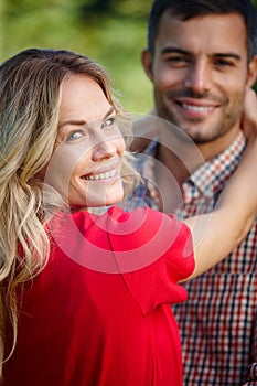 Portrait, couple and hug with smile in nature for bonding, love and relationship outdoors. Happy, woman and man embrace