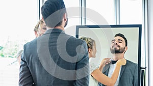 Portrait of couple love or bride in wedding fashion dress up interior studio while groom man tries to fitting suit and dress