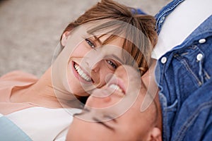 Portrait, couple and love with care while lying down for affection at home. Man, woman and relax in relationship with